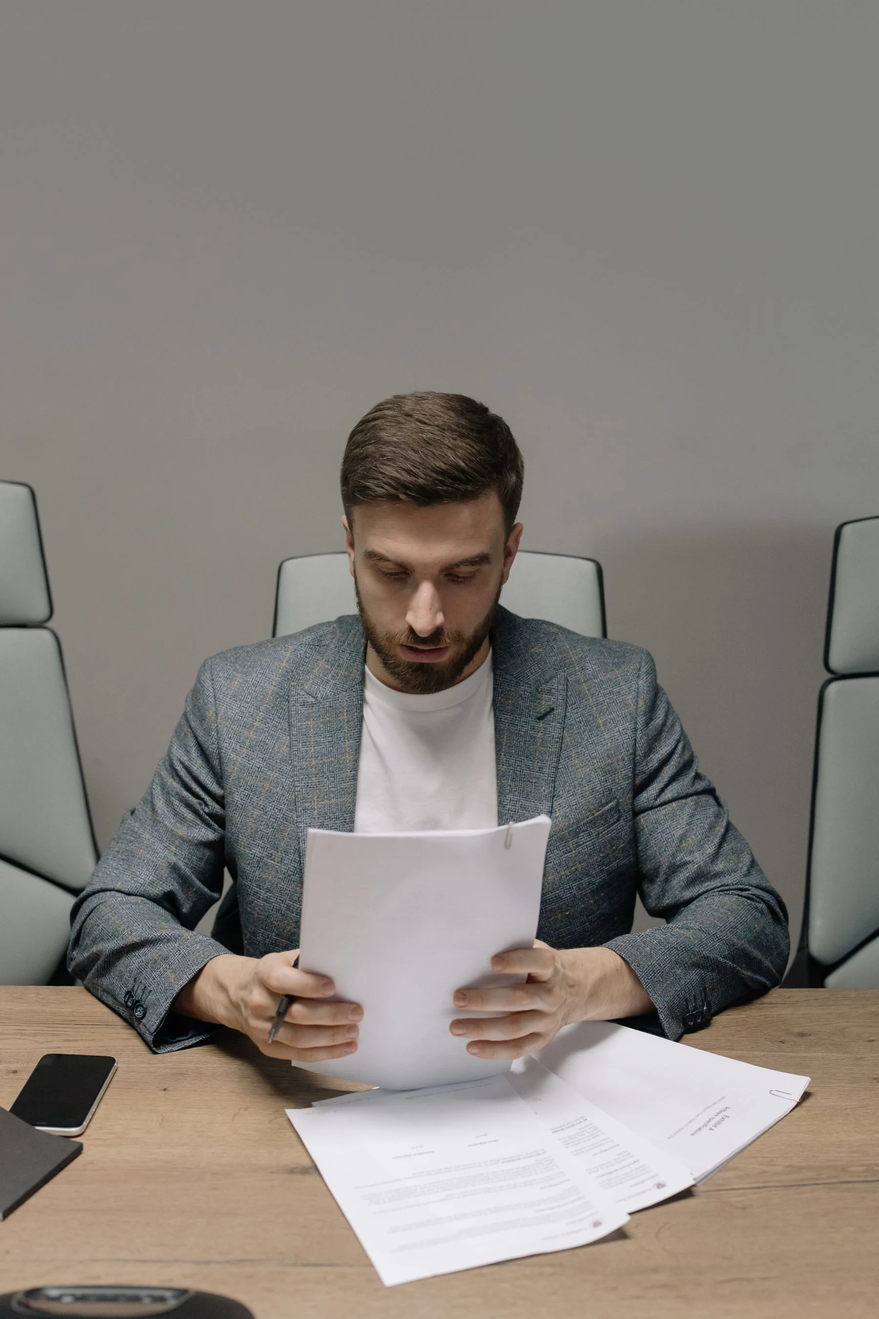 A professional reading reference documents at a desk
