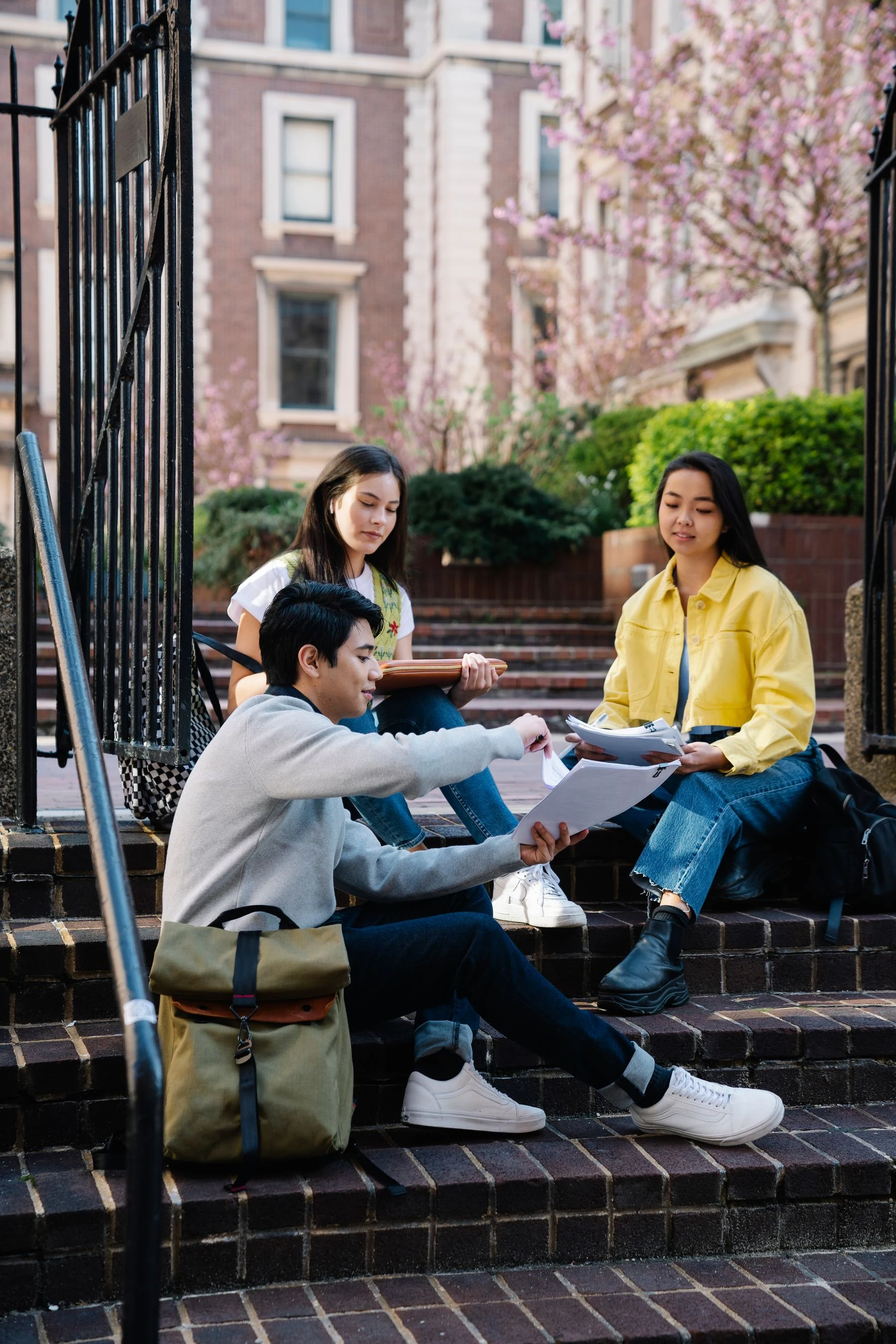 University students studying and reviewing notes on campus steps