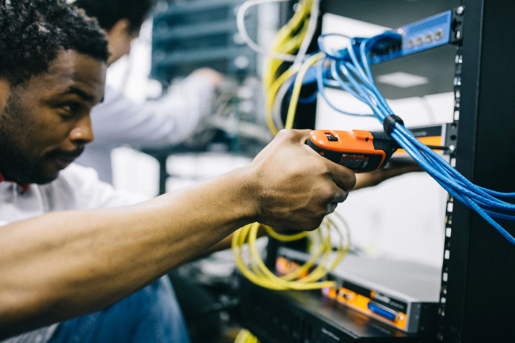 An engineer inspecting network cabling and equipment